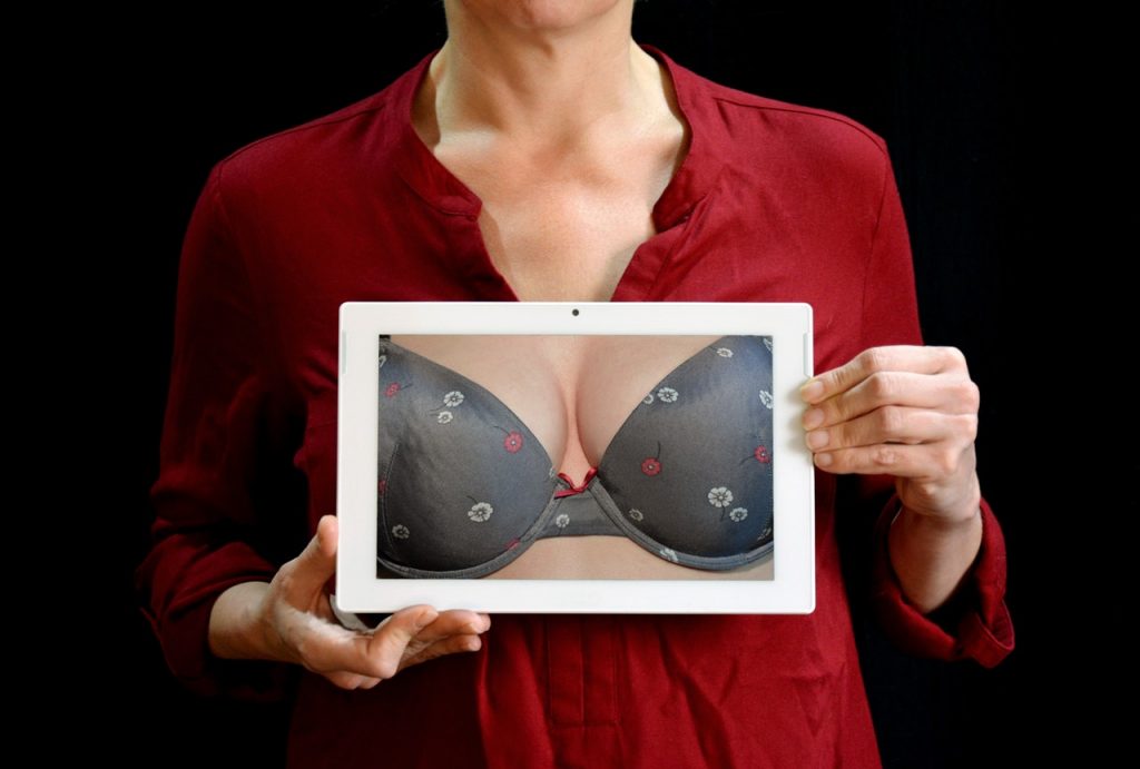 Femme qui tient une pancarte avec des faux seins