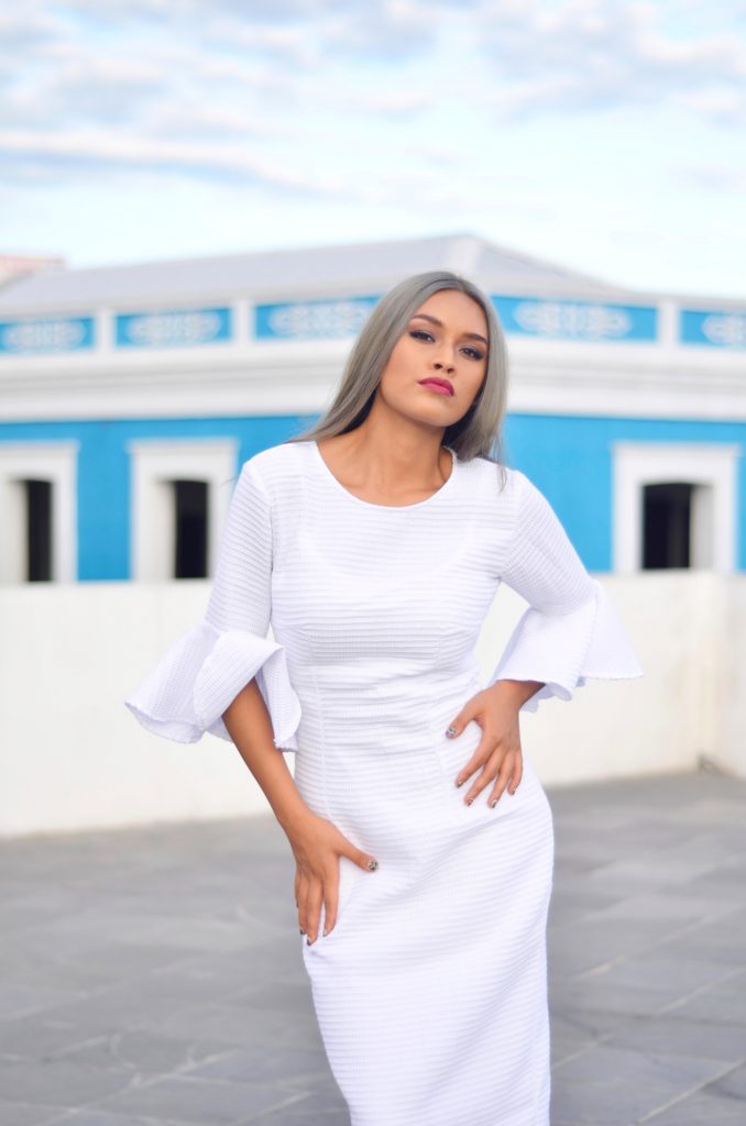 femme portant un robe blanche près du corps avec manches à volants